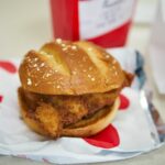 a chicken sandwich sitting on top of a piece of paper